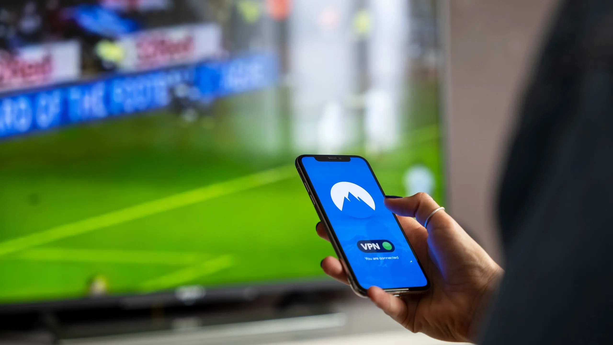 Smartphone affichant l'application Winamax avec cotes football et table de poker en arrière-plan